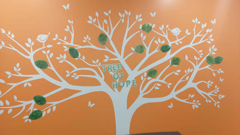 The tree of hope mural on the wall of the visitors room