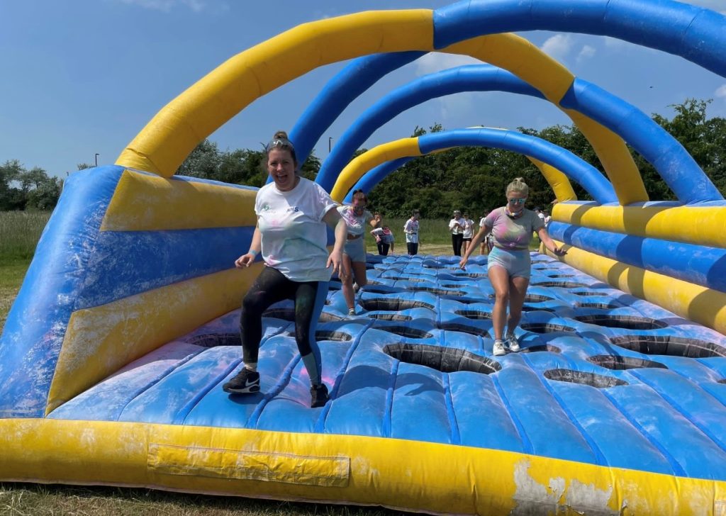 St Bedes staff running through an obstacle at the 2023 colour run.
