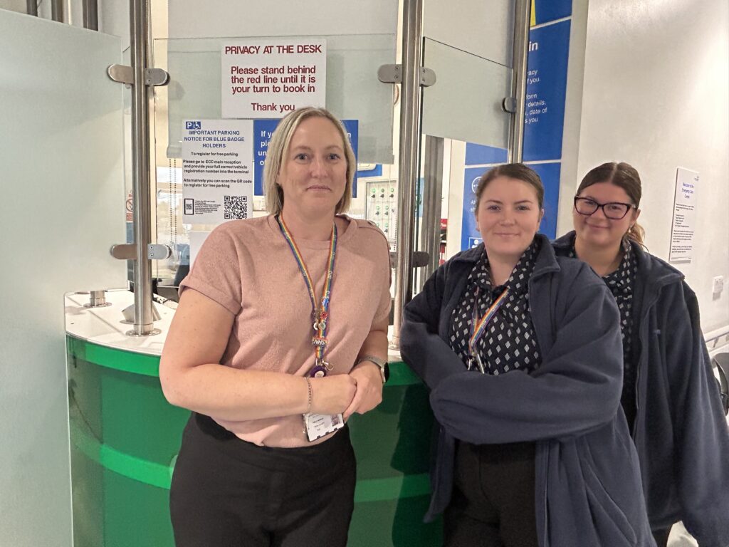 Three members of reception staff at accident and emergency reception