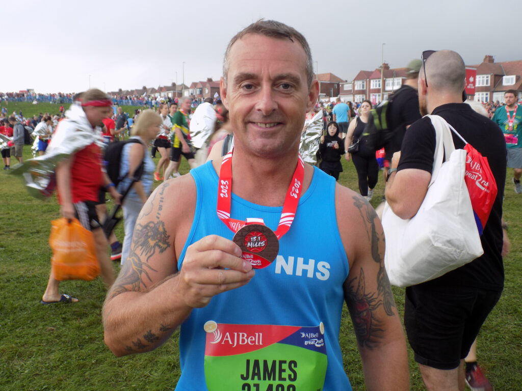 man GNR runner at event with medal