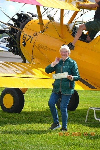 Brenda stood in front of yellow plane she completed wing walk on