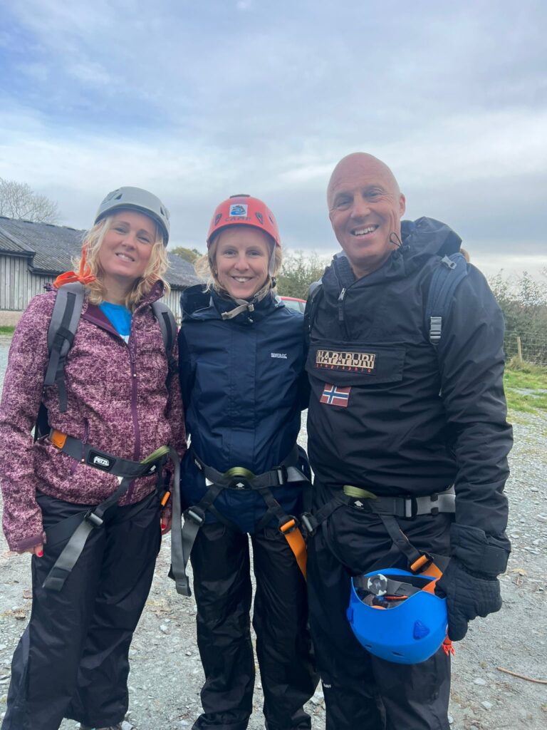 picture of a dad and his two daughters in climbing gear