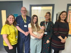 A group photo of maternity staff, one of whom is holding a baby.