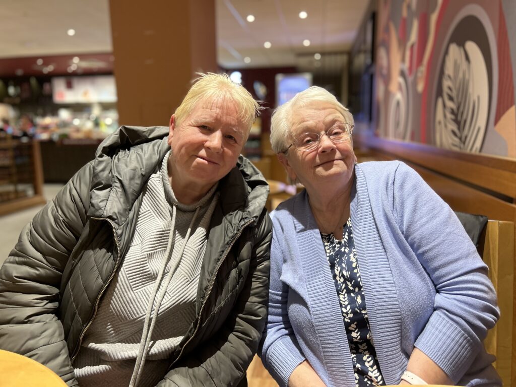 2 women posing for a photo in a coffee shop