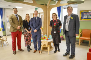 A group of people in front of the feature tree in the children's department.