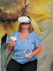 A person is wearing a VR headset and holding the VR controllers
