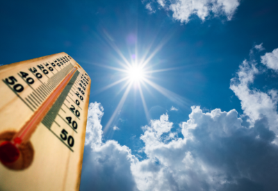 A decorative image showing a bright sun in the sky and a thermometer