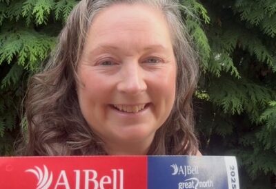 Headshot photo of Kris, one of our charity runners, holding her great north run number.