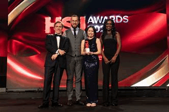 A group of four people receiving an award at the HSJ awards ceremony