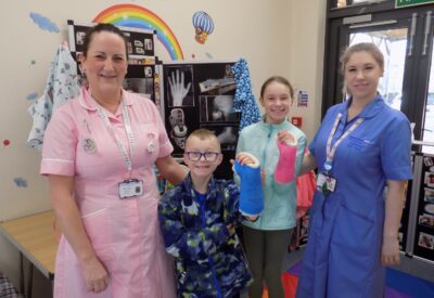 A picture of a young boy and girl with their arms in plaster casts with Wendy Oliver and Helen Ramm